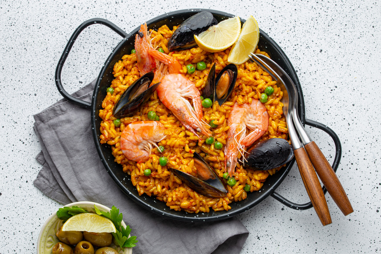 classic dish spain seafood paella traditional pan white wooden background top view spanish paella with shrimps clamps mussels green peas fresh lemon wedges from