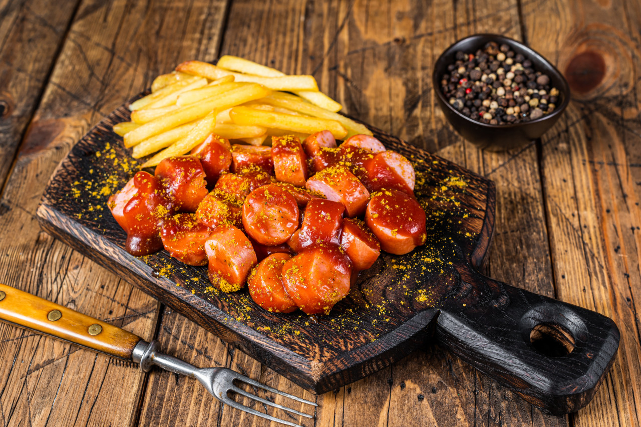 currywurst sausages street food served french fries wooden board