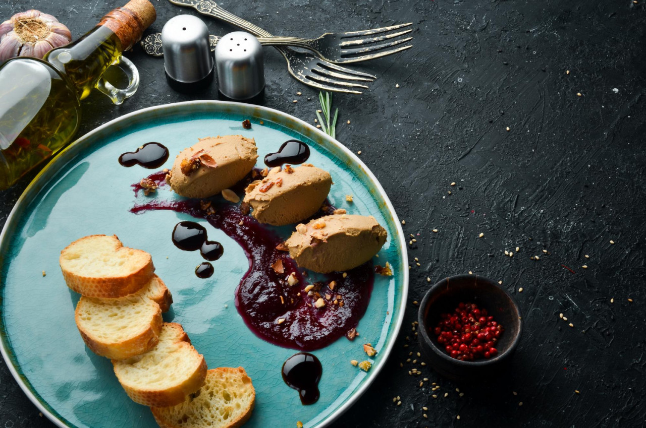 goose liver pate with soy sauce and toast on a black stone background top view rustic style