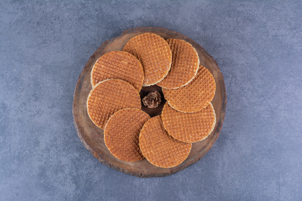 stroopwafels with pinecone isolated wooden plate stone high quality photo