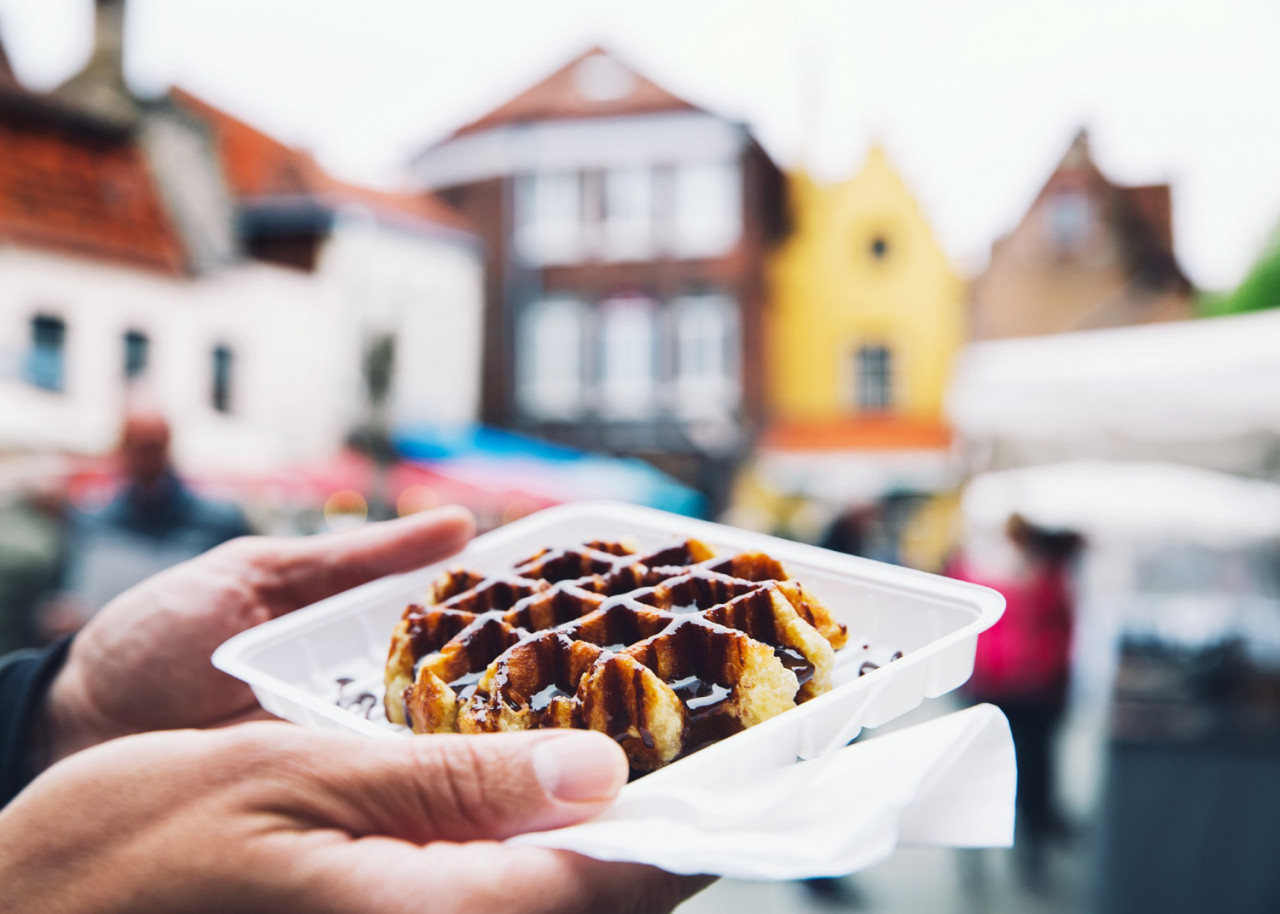 tourist holds hand popular street food belgium tasty waffle with chocolate sauce