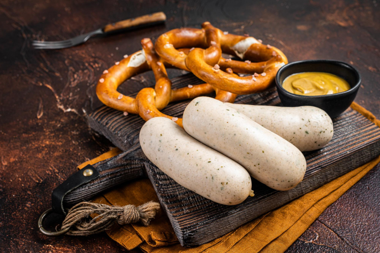 traditional german pretzel with white sausage mustard dark background top view
