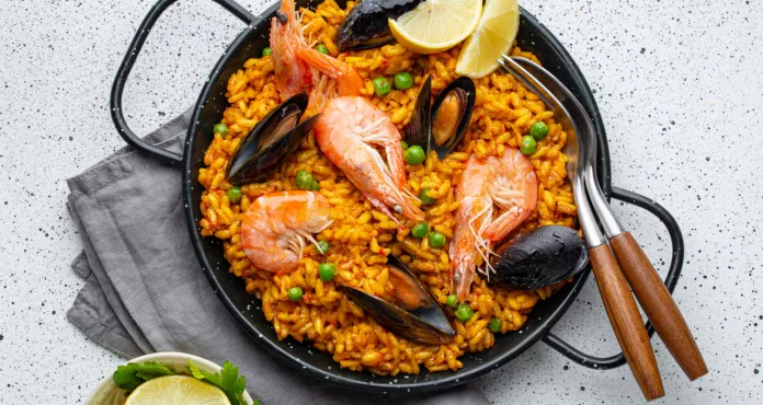 Classic Dish Spain Seafood Paella Traditional Pan White Wooden Background Top View Spanish Paella With Shrimps Clamps Mussels Green Peas Fresh Lemon Wedges From