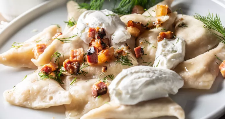 Filled Pirohy Dish Served With Fried Bacon Fresh Dill And Sour Cream
