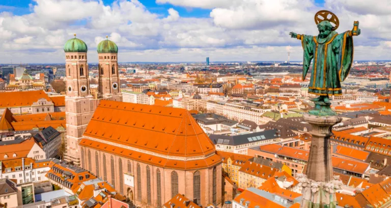 Frauenkirche Surrounded By Buildings Sunlight Cloudy Sky Munich Germany