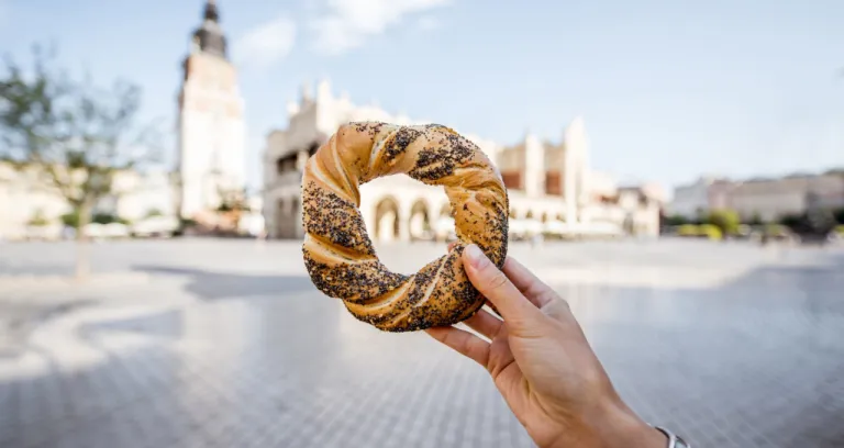 holding prezel traditional polish snack market square krakow