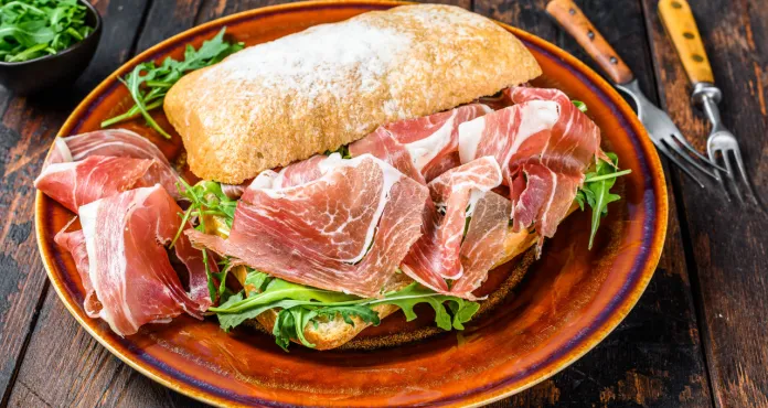 Spanish Bocadillo De Jamon Serrano Ham Sandwich Ciabatta Bread With Arugula Dark Wooden Background Top View
