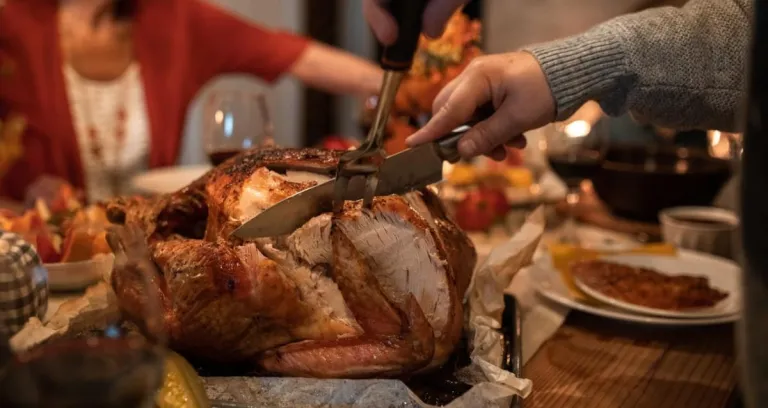 Person Slicing Meat On Table