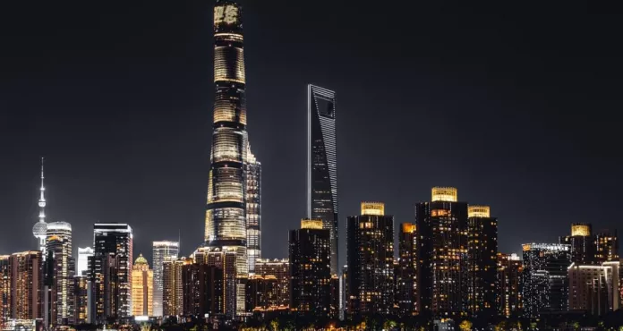 The Illuminated Shanghai Tower With City Buildings At Night