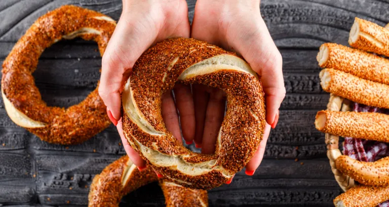 Top View Woman Holding Turkish Bagel Dark Wooden Surface Horizontal