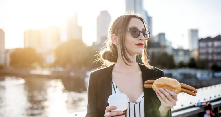 Young Businesswoman Having Snack With Traditional Franfurt Sausage Coffee Bridge With Skyscrapers Background Frankfurt During Sunset