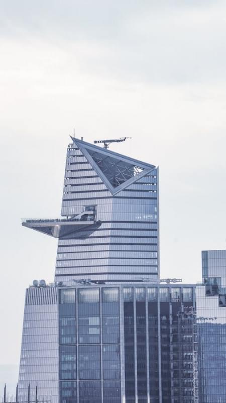 a bird flying over a tall building in the city