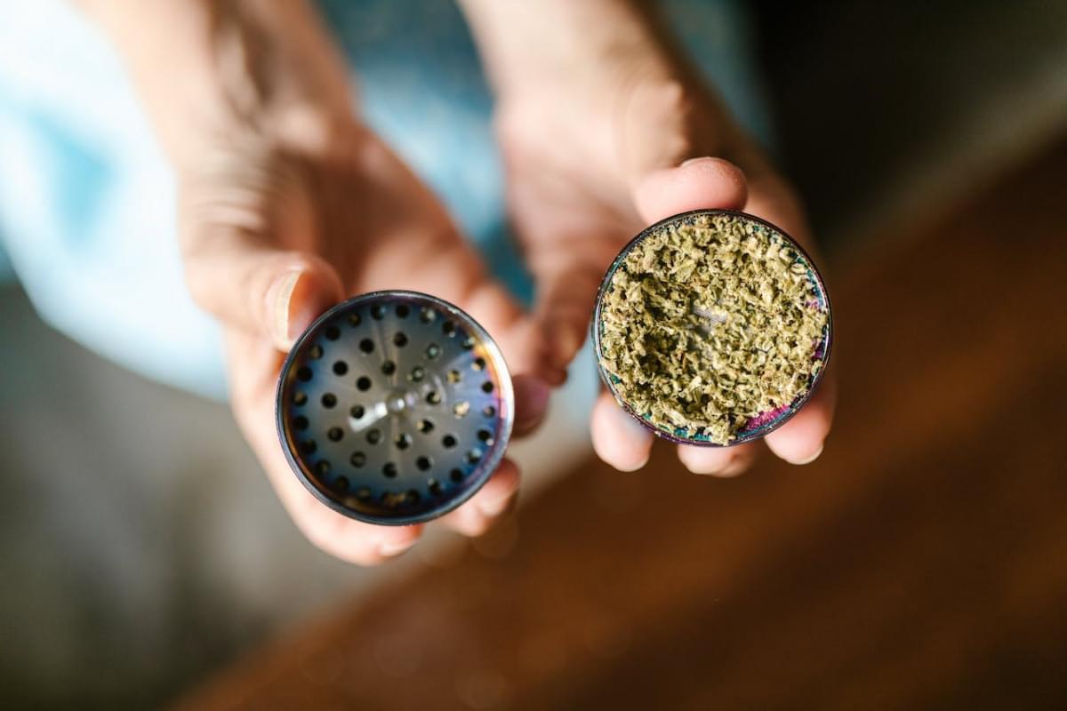 a person holding a tin can with dried leaves