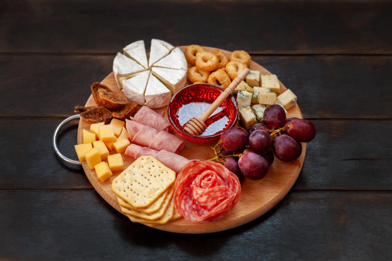 appetizers board with assorted cheese meat sausage rosette grape salty cookies charcuterie cheese platter top view