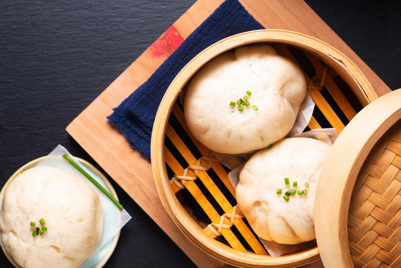 asian food concept chinese meat dumpling baozi dim sum bamboo steamer wooden board black slate stone background with copy space