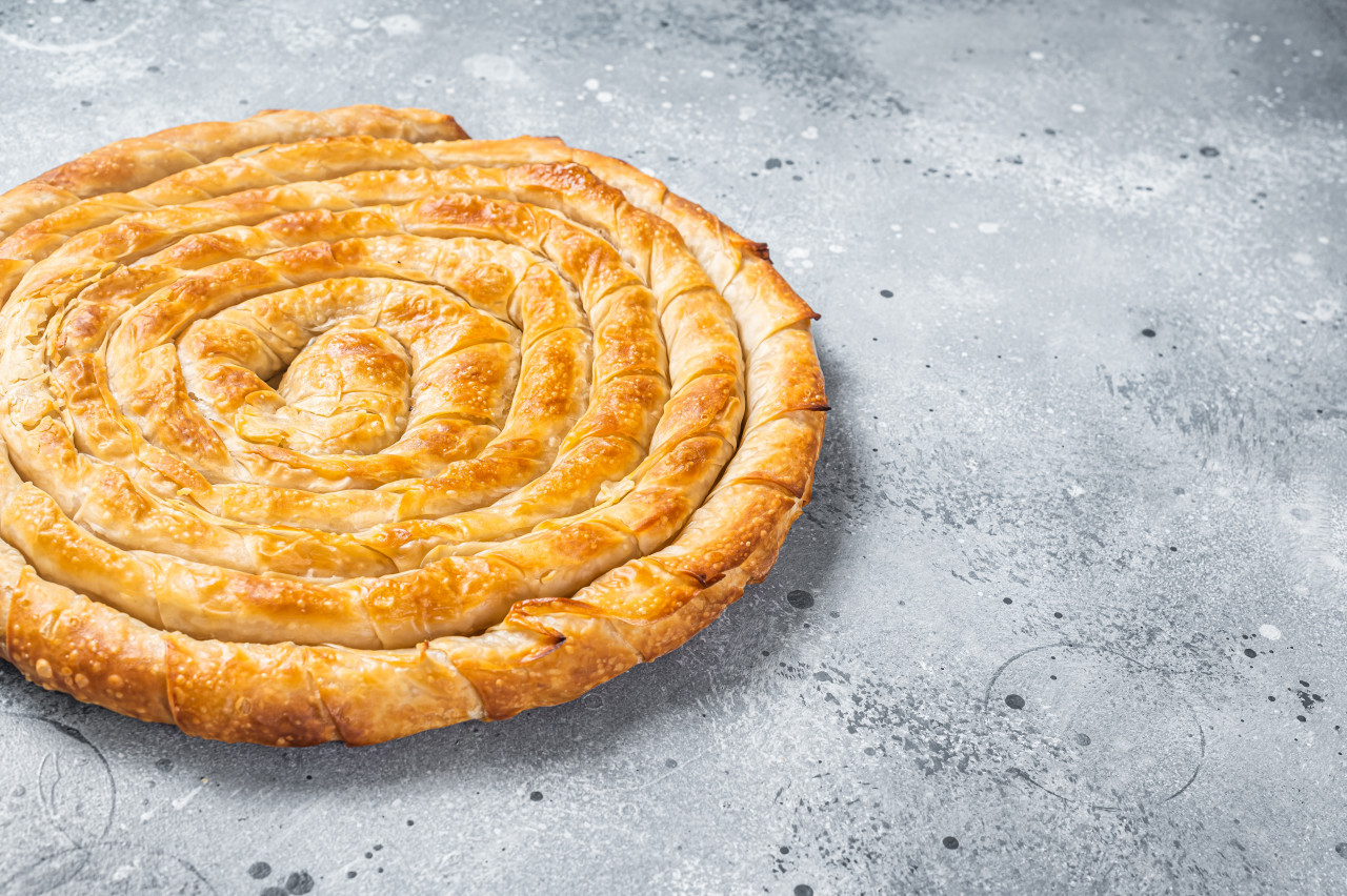 baked homemade traditional greek cheese pie kitchen table gray background top view copy space