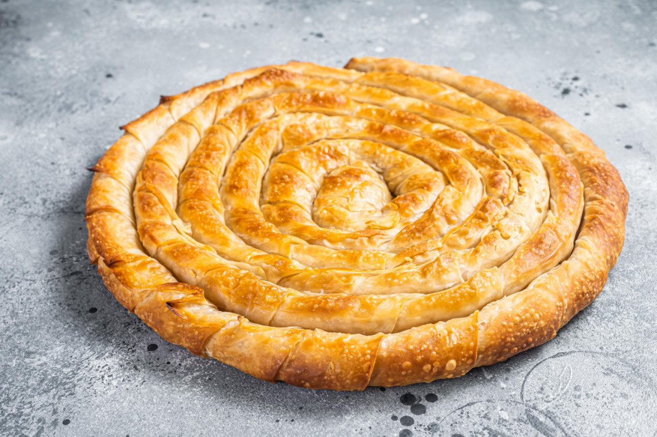 baked homemade traditional greek cheese pie kitchen table gray background top view