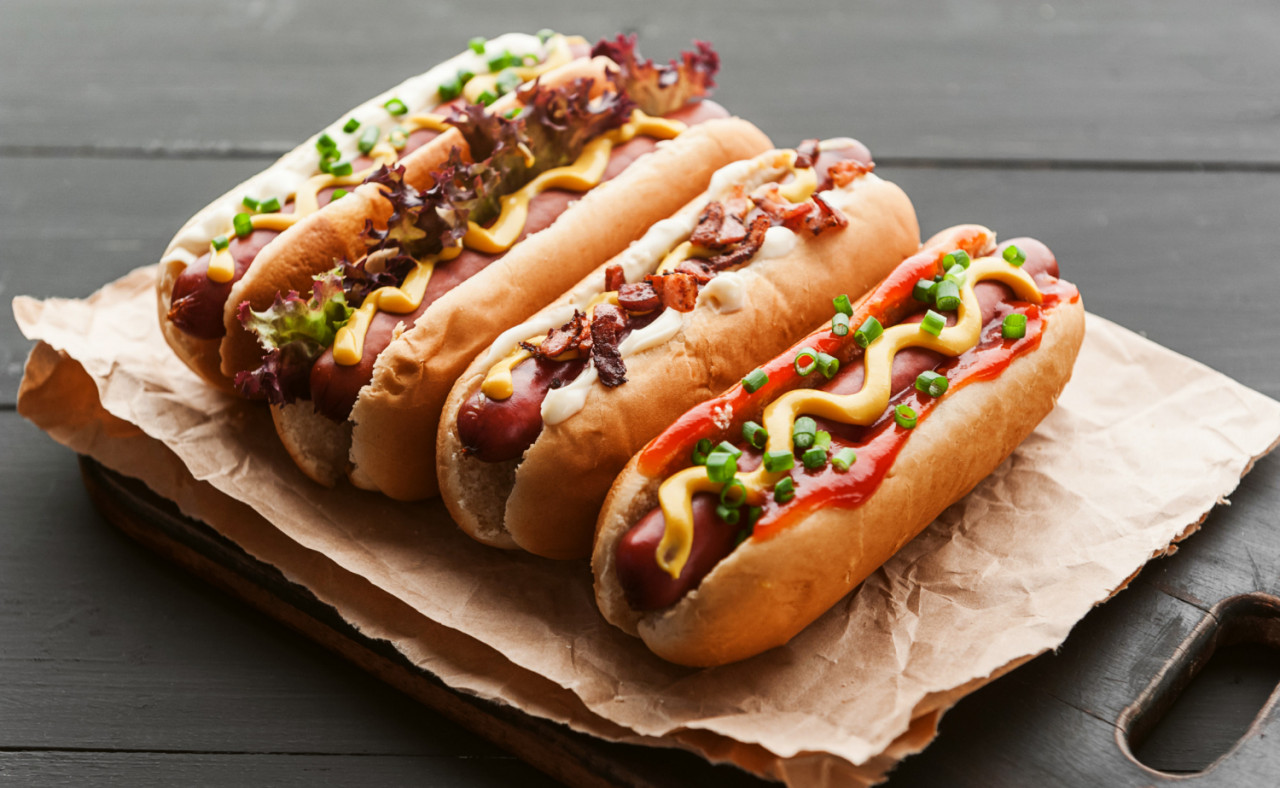 barbecue grilled hot dogs with yellow american mustard dark wooden background
