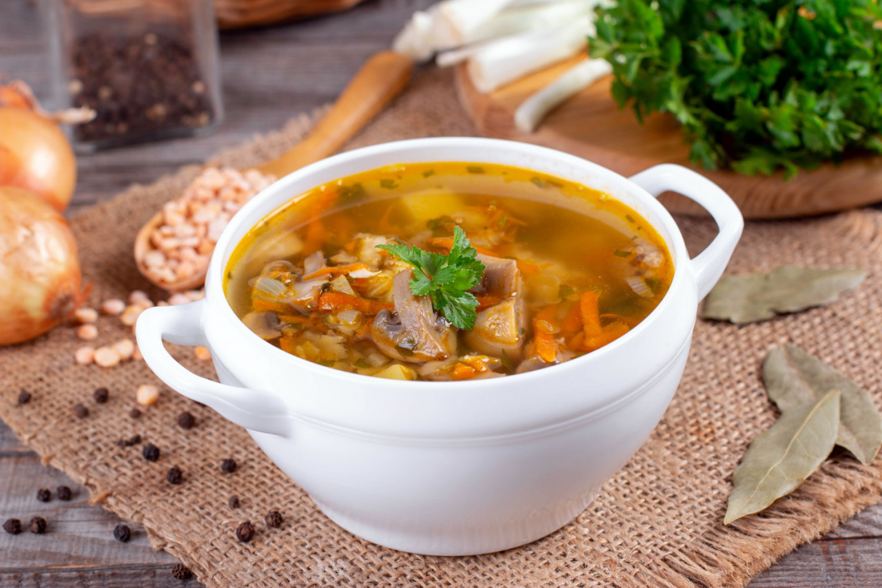 bowl of pea soup with mushrooms on an old wooden table