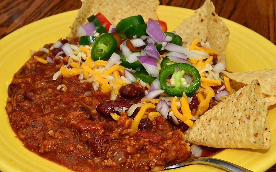 chili with garnishes and tortilla chips
