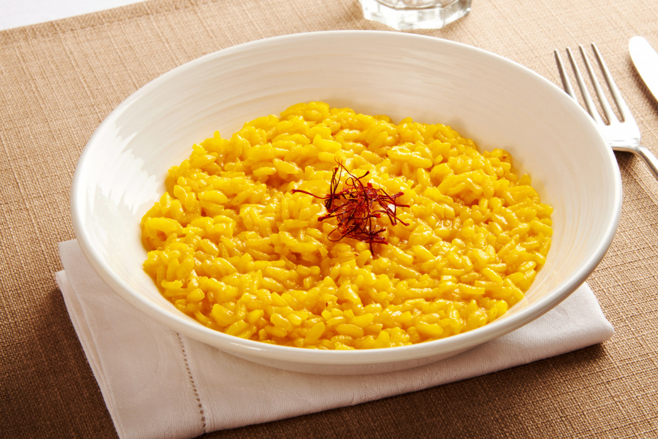 ciotola di risotto giallo con fili di zafferano