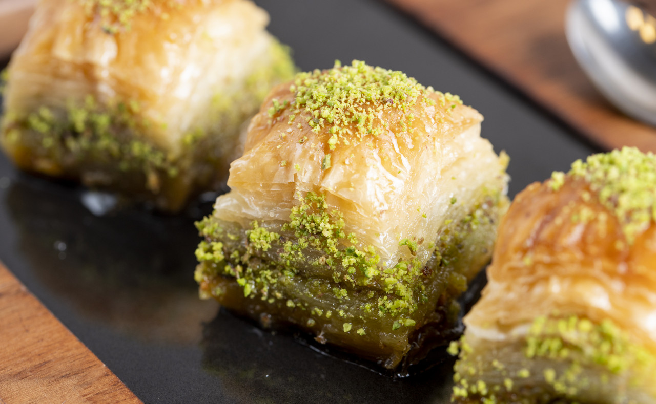 close up view traditional turkish baklava with pistachio black board