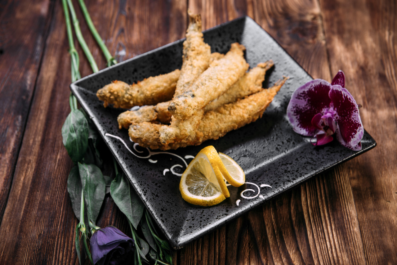 closeup deep fried capelin with slices lemon