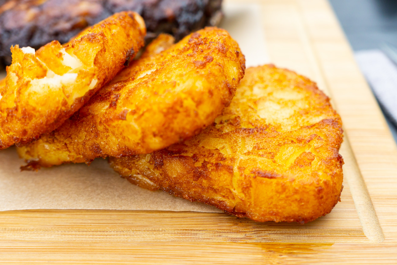 closeup pile fried hashbrowns wooden deck