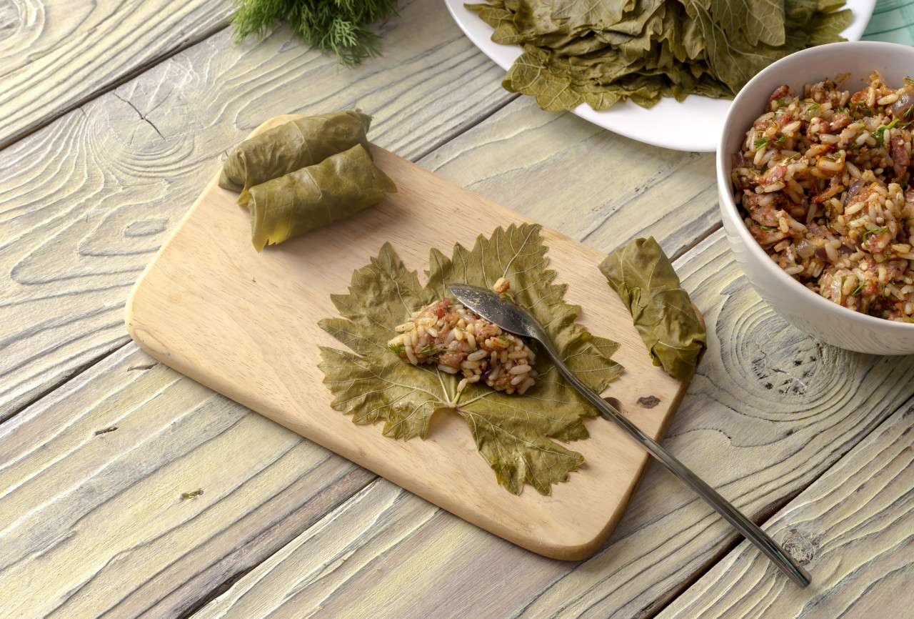 cooking food preparation dolmas grape leaves wooden table closeup