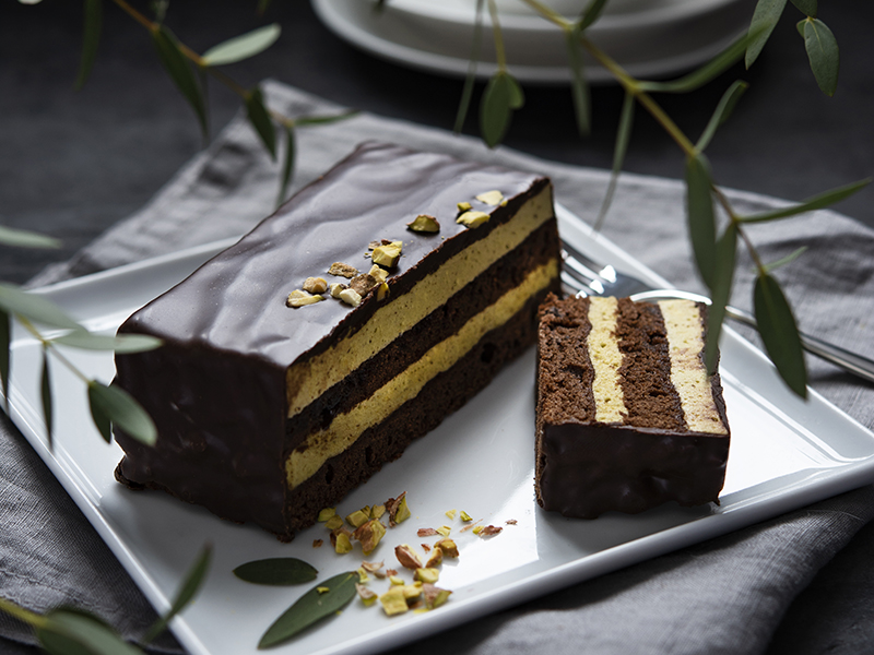 delicious chocolate mozart cake with pistachious square plate morning light window dark background