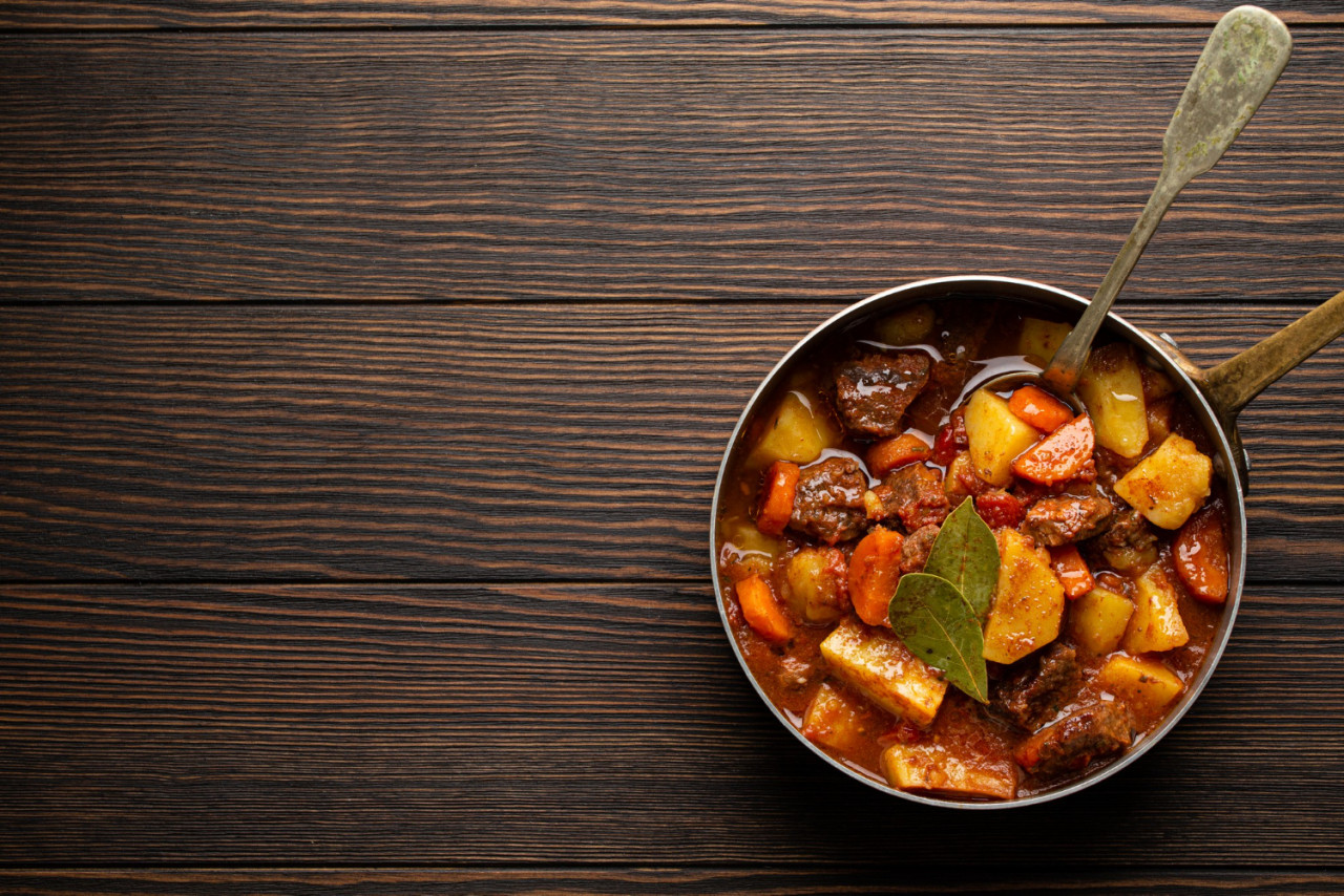 delicious stew with meat potatoes carrot gravy rustic copper pot brown wooden background from traditional winter autumn dish beef vegetables ragout stewpot copy space