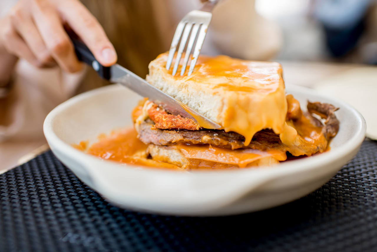 Eating Traditional Portuguese Meat Sandwich With Tomato Sauce Called Francesinha Restaurant Porto City