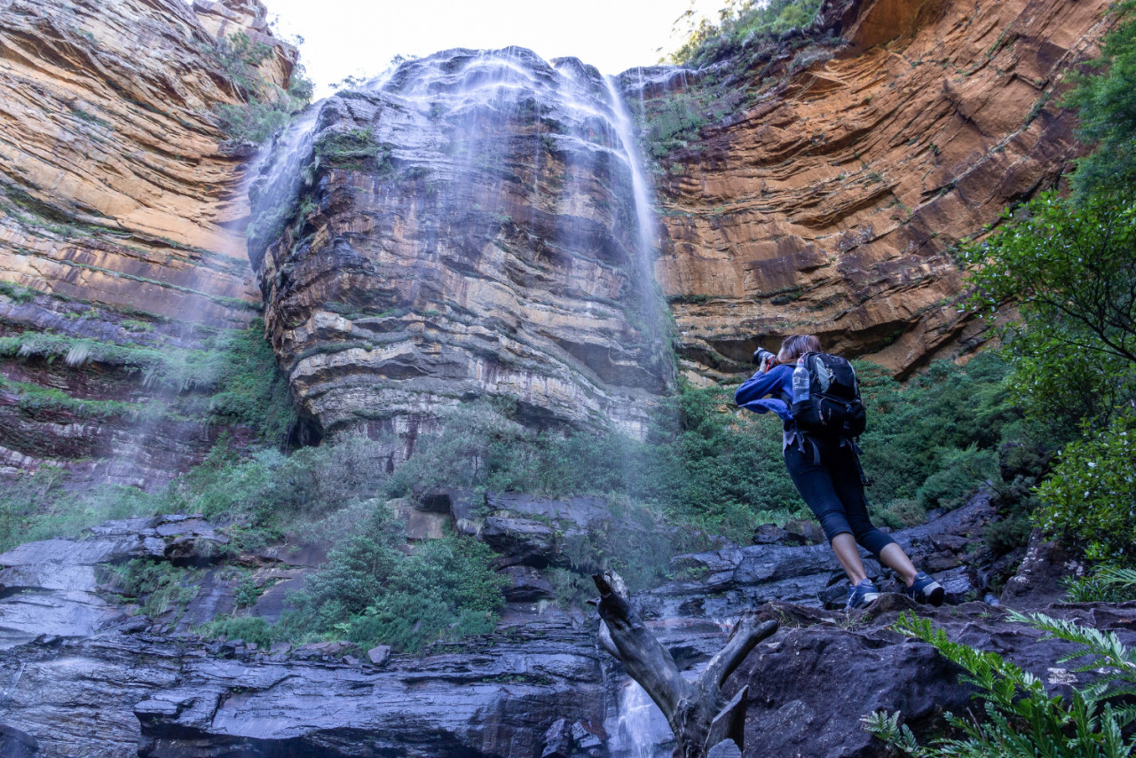 female tourist with backpack bag take photo wentworth falls waterfall