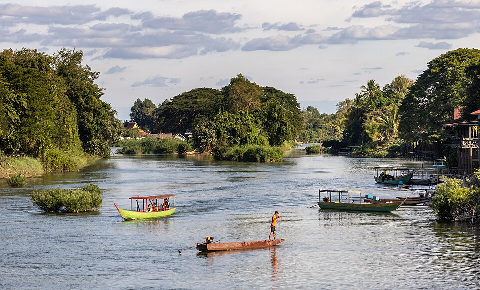 fisherman and pirogue sailing on the mekong a sunny afternoon in don det laos