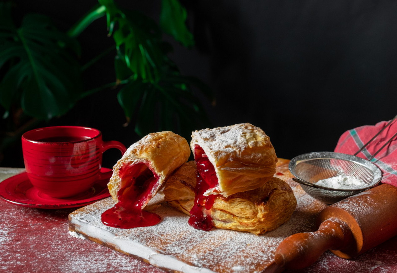 fresh puff staffed with plum red currant jam table with red cup jar jam