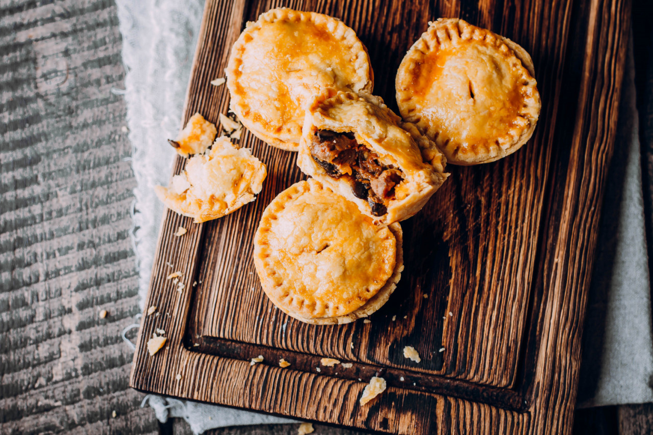 fresh traditional australian meat mini pie wooden board table closeup with copy space rustic style