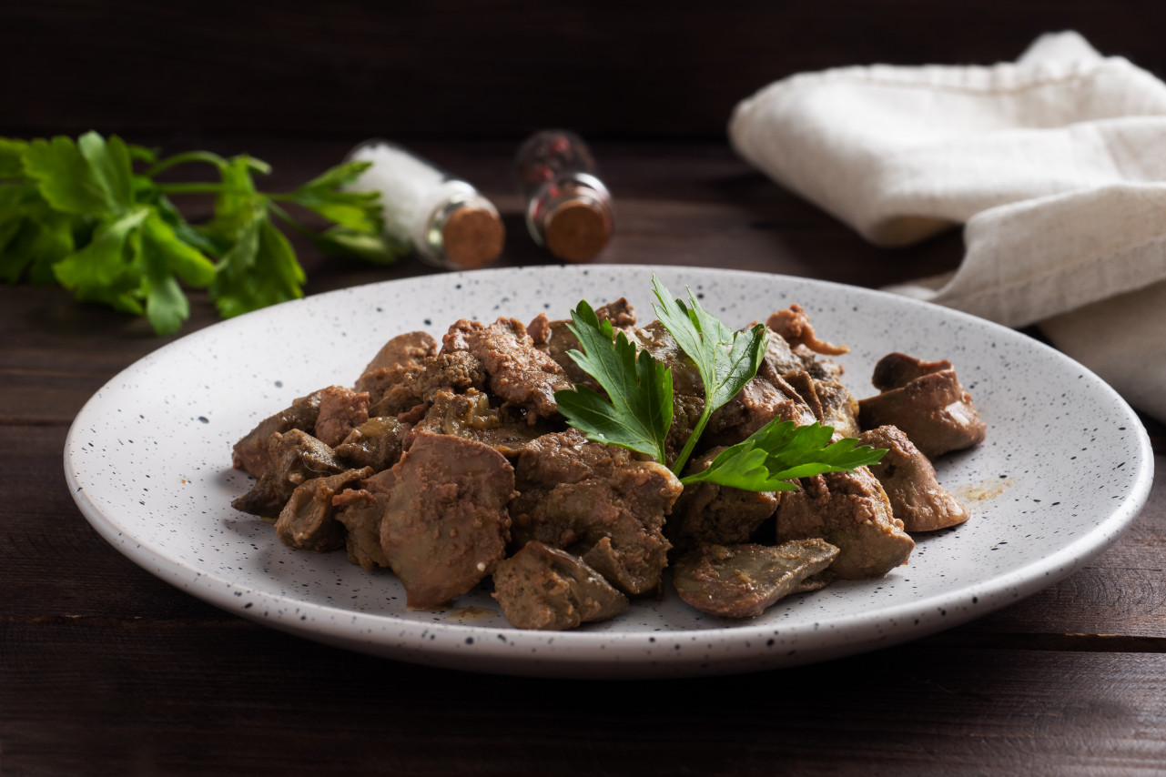 fried baked chicken liver with onion sauce green parsley leaves plate meat dish enriched with iron