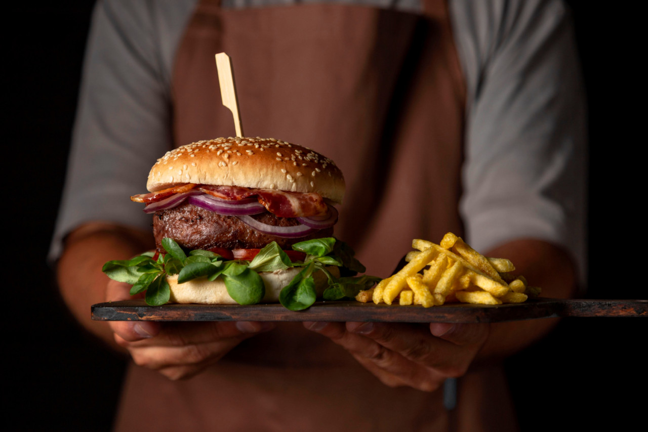 front view male holding tray with burger fries