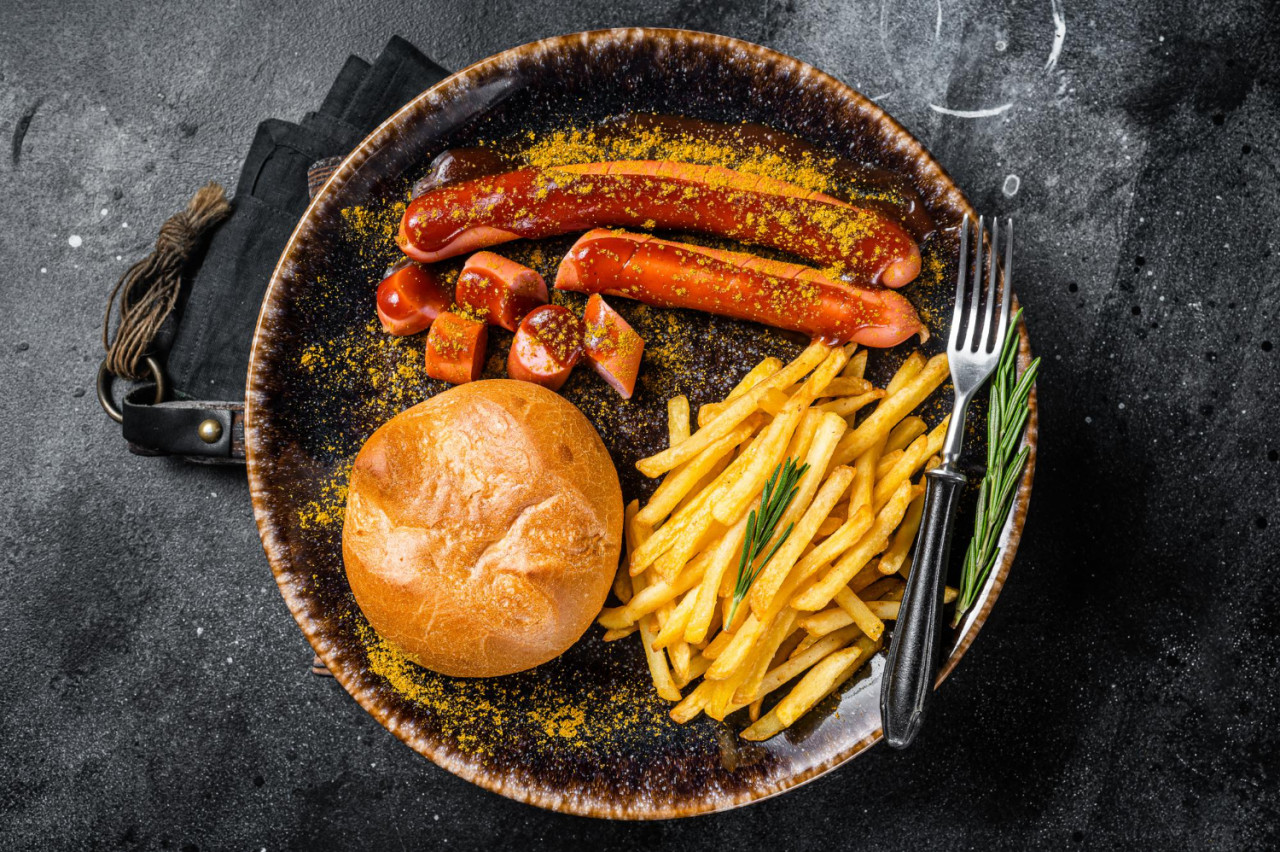 german currywurst sausage curry wurst served with french fries dark background top view