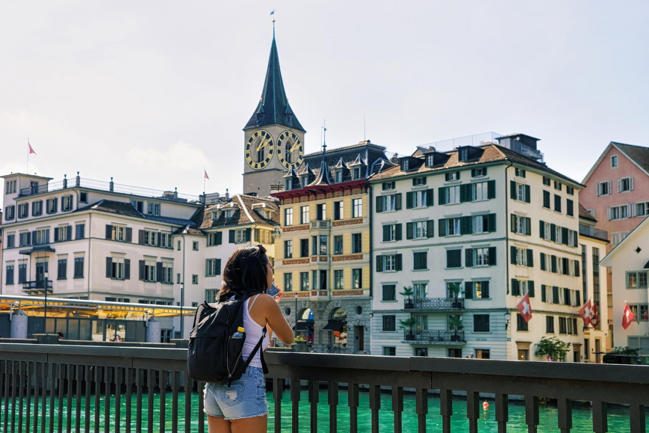 girl taking photo limmatquai saint peter church city center zurich switzerland