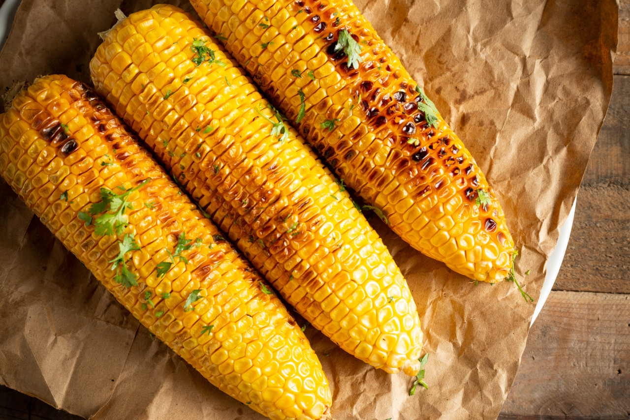 grilled corn cobs wood background