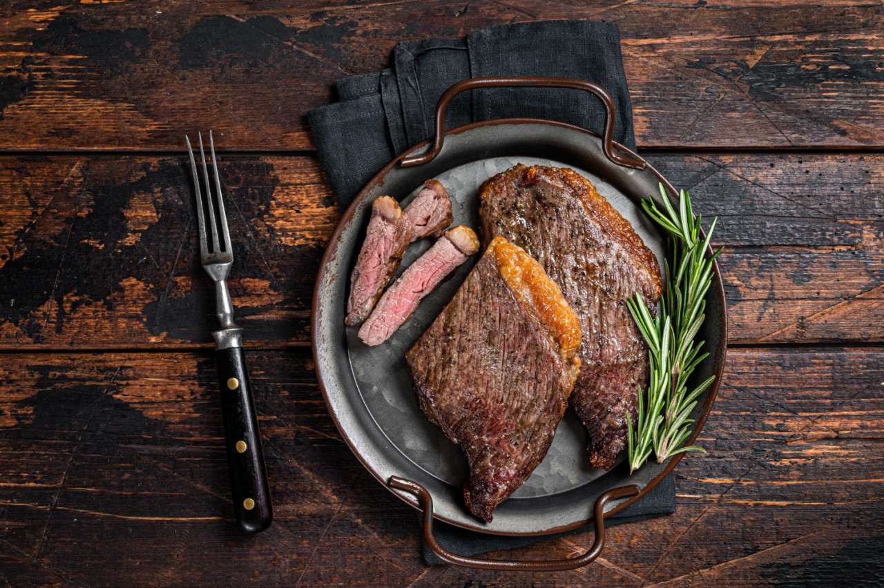 grilled picanha top sirloin beef steak with rosemary steel tray wooden background top view