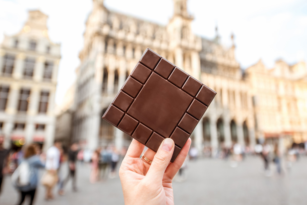 holding dark chocolate bar central square background brussels belgium is famous its chocolate