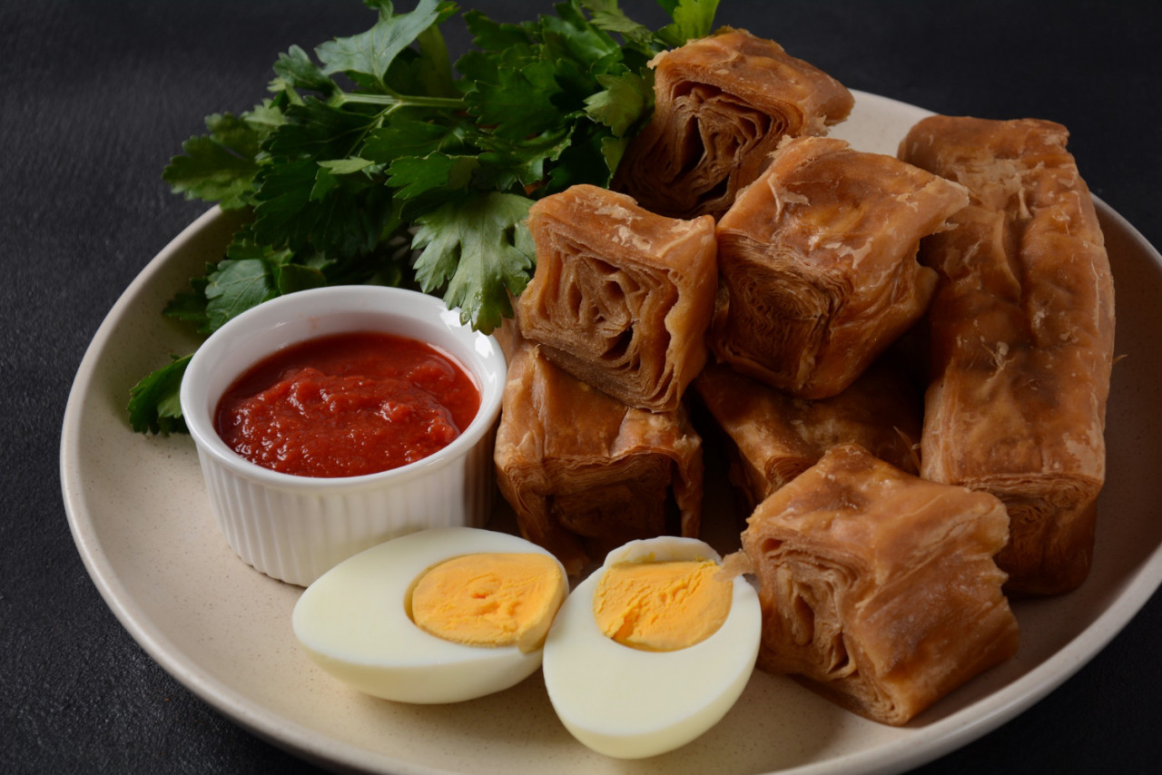 jachnun jahnun yemenite jewish pastry served with fresh grated tomato boiled egg zhug originating from adeni jews traditionally served shabbat morning israel