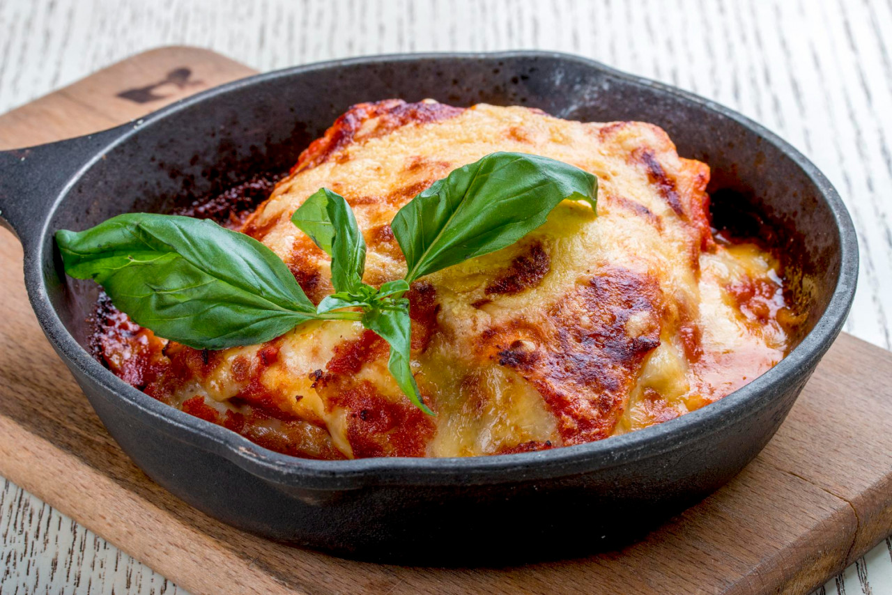 lasagna cast iron pan wooden board traditional italian dish