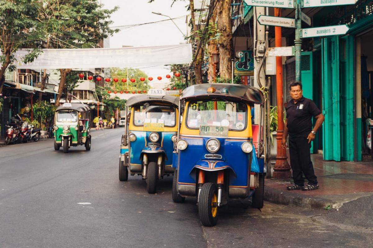 man standing beside parked trikes