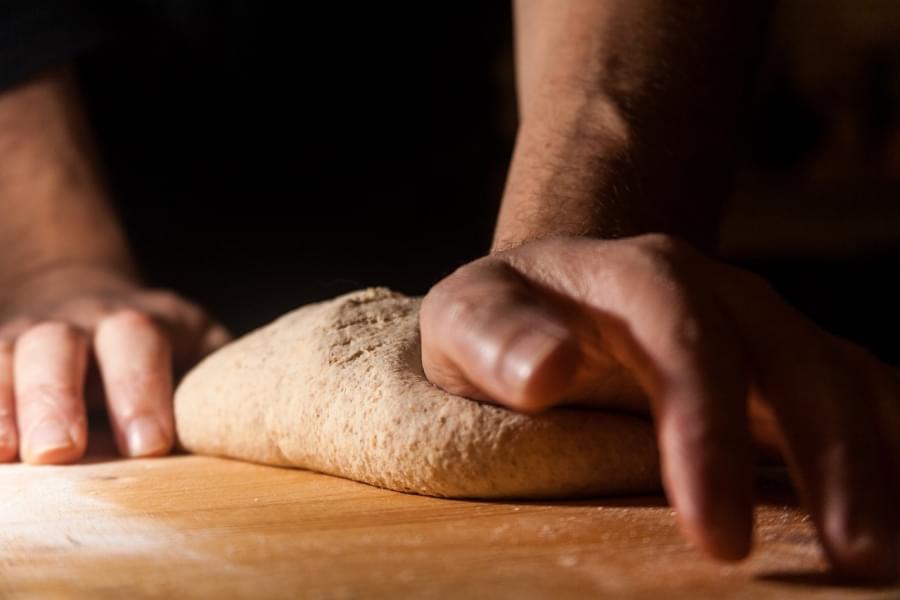 mani che impastano il pane