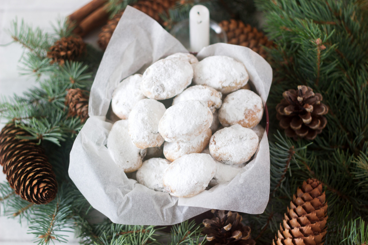 mini stollen or stollen candy in a tin on a background of fir branches and cones