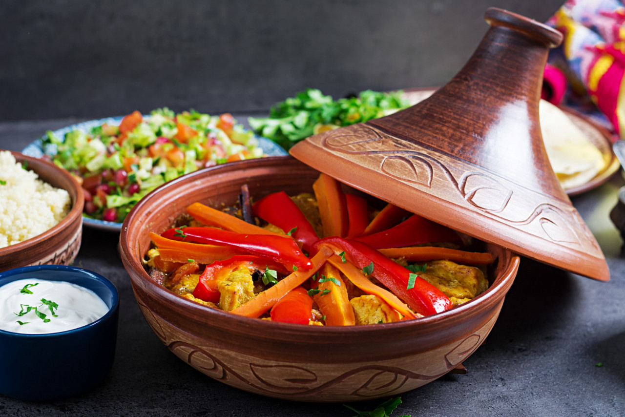 moroccan food traditional tajine dishes couscous fresh salad rustic wooden table tagine chicken meat vegetables arabian cuisine