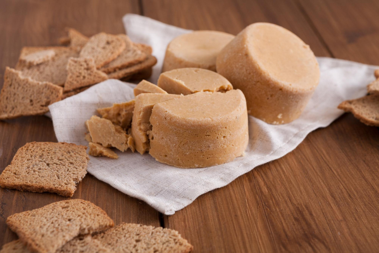 norwegian homemade brown cheese brunost with crackers crispbread wooden desk close up selective focus